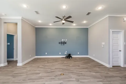 an empty room with painting and a ceiling fan