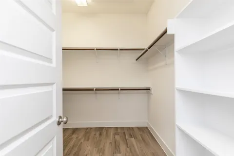 a view of walk in closet with empty racks