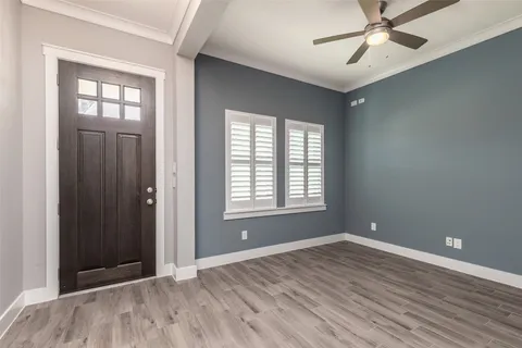 a view of an empty room with window and wooden floor