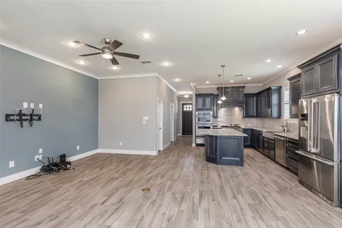 a view of kitchen with stainless steel appliances refrigerator stove microwave and cabinets