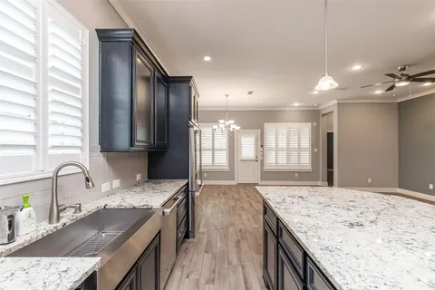 a kitchen with granite countertop sink stove and refrigerator