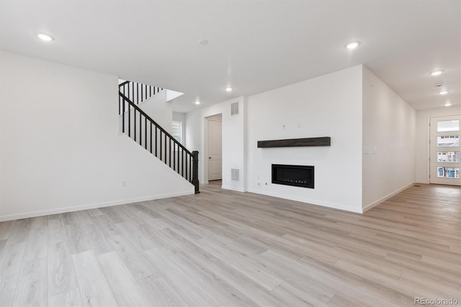 2144 South Ider Way Aurora, CO 80018 - Photo 15 of 27 a view of an empty room with wooden floor and a fireplace