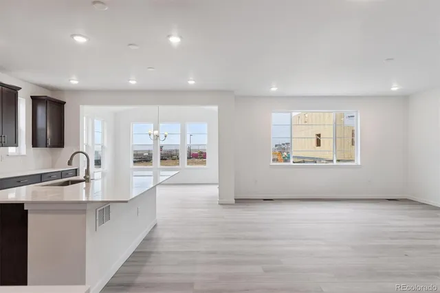 a view of kitchen with stainless steel appliances granite countertop a sink and dishwasher with wooden floor