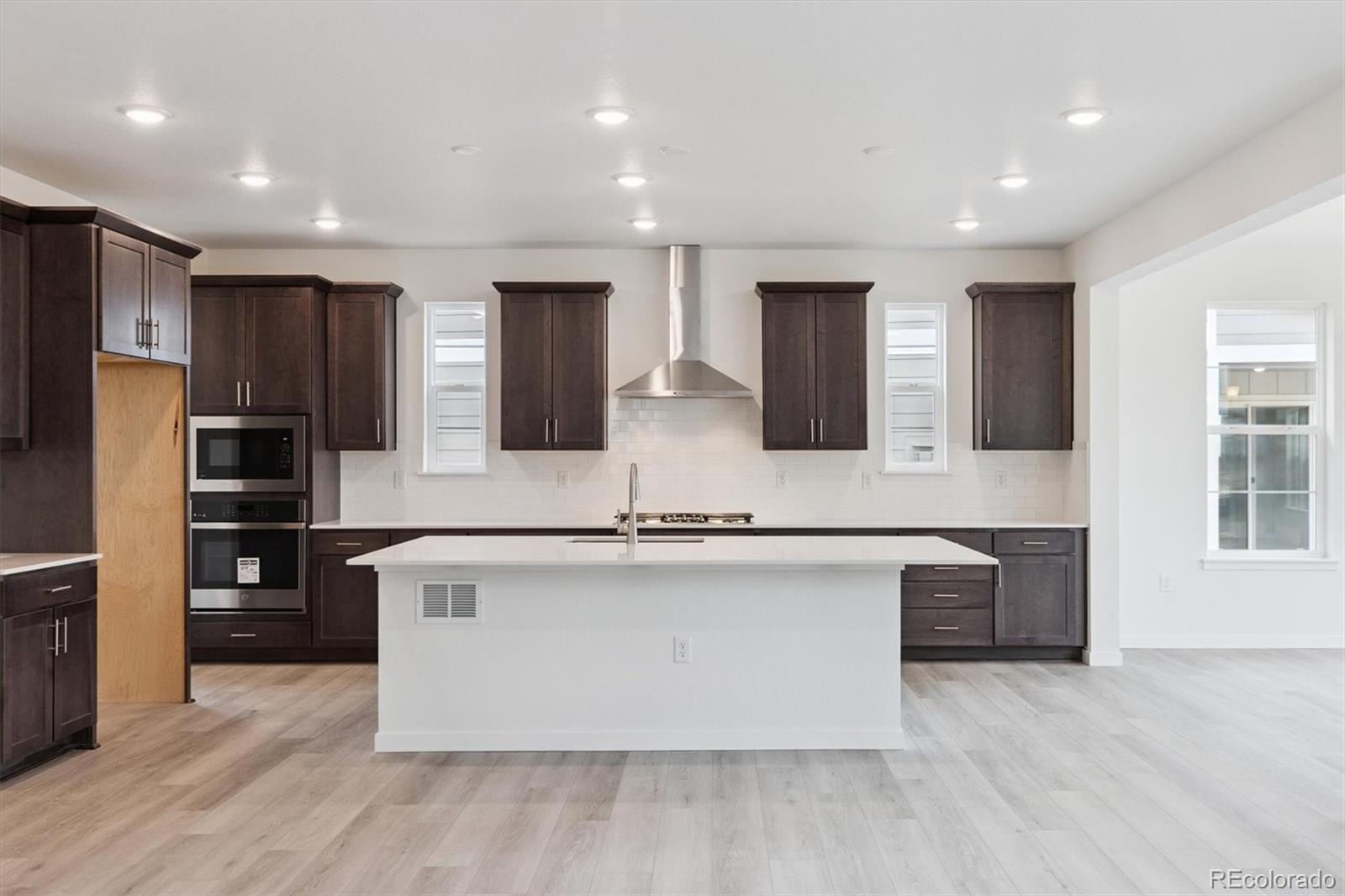 2144 South Ider Way Aurora, CO 80018 - Photo 9 of 27 a large kitchen with stainless steel appliances granite countertop a large counter top and wooden floors