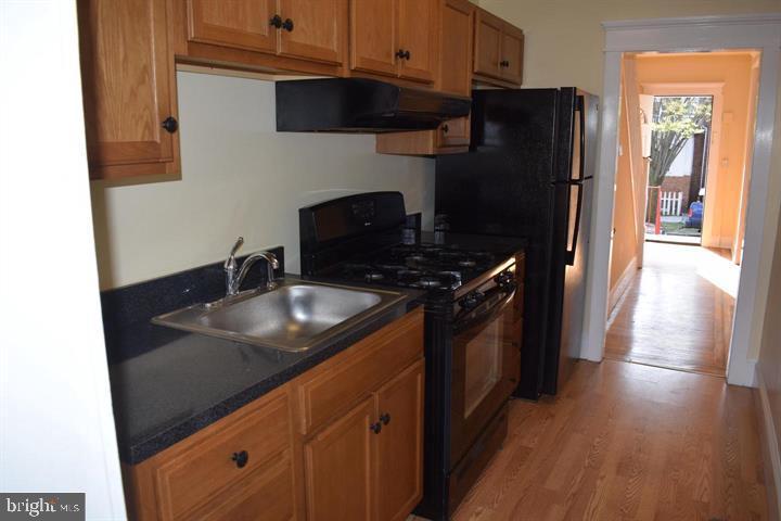 a kitchen with granite countertop a sink stove and refrigerator