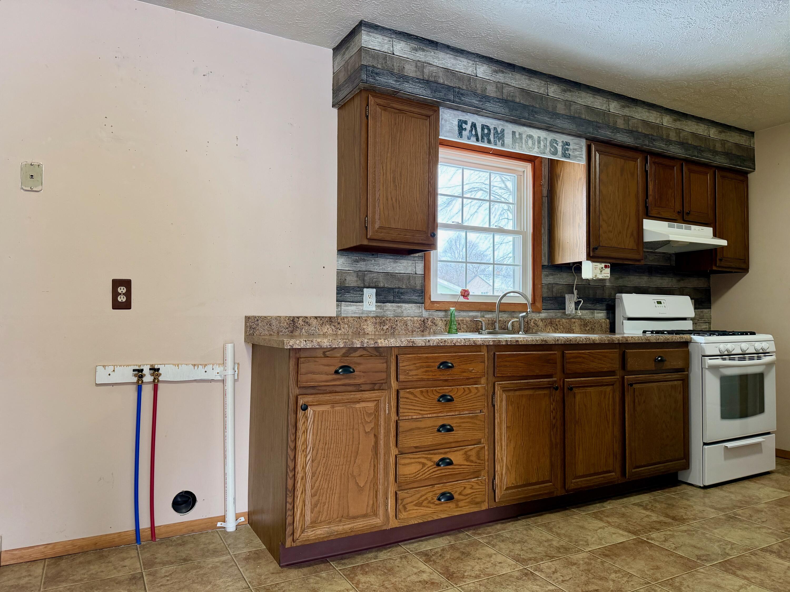 402 East St Louis Street Knox, IN 46534 - Photo 5 of 19 a kitchen with granite countertop a sink and a stove