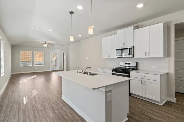 a kitchen with a sink a stove a microwave and cabinets