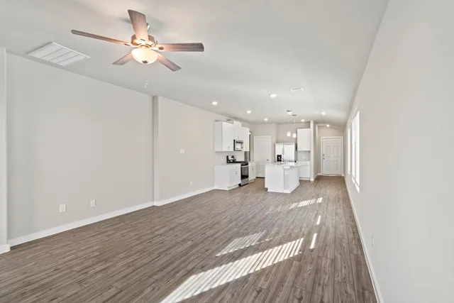 a view of a kitchen with a sink dishwasher a refrigerator with wooden floor