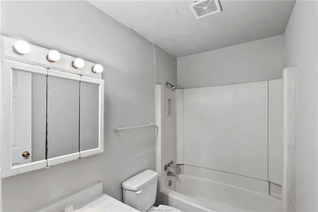 a bathroom with a bathtub a toilet and a shower