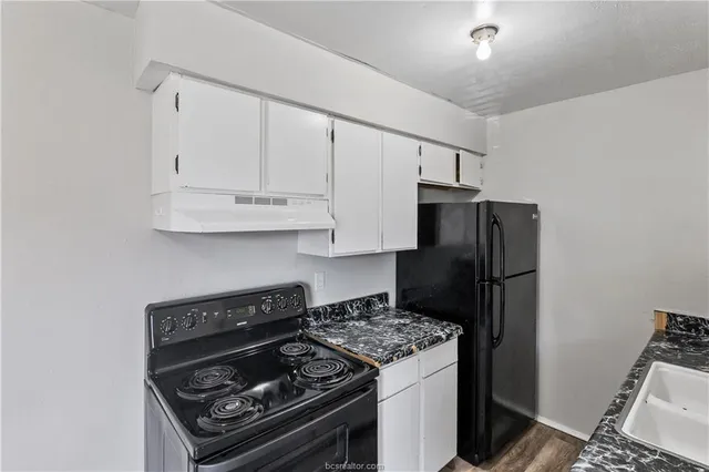 a kitchen with a refrigerator and a stove top oven
