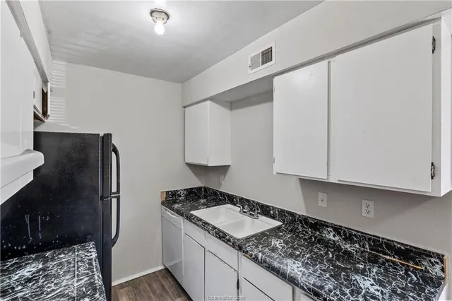 a kitchen with granite countertop a stove and a sink