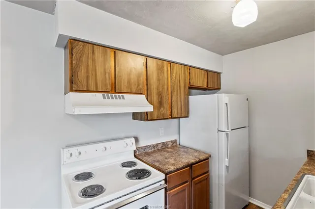 a kitchen with a refrigerator and a stove