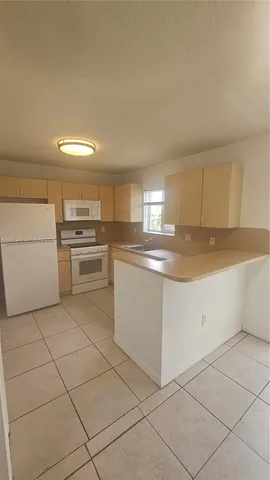 a kitchen with cabinets and white stainless steel appliances