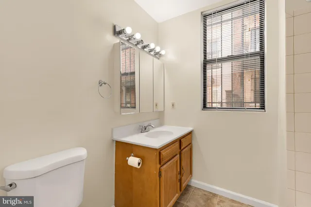 a bathroom with a sink a toilet and mirror