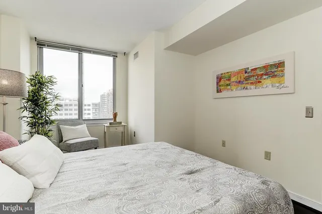 a bedroom with a bed and a large window