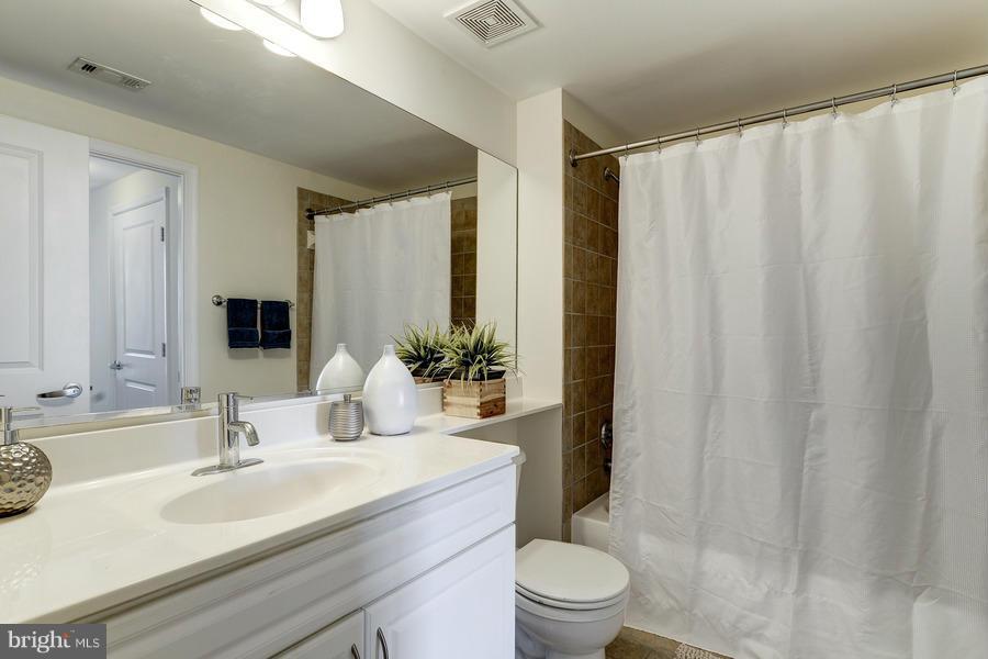 555 Massachusetts Avenue Northwest, Unit 806 Washington, DC 20001 - Photo 15 of 22 a bathroom with a granite countertop sink a toilet and shower
