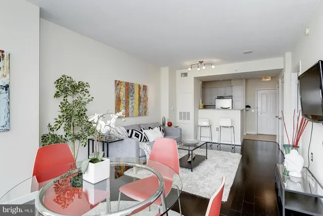 a living room with furniture a flat screen tv and a large window