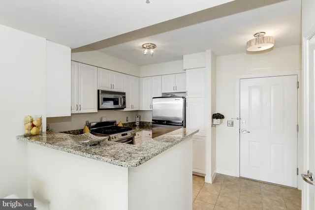 a kitchen with stainless steel appliances granite countertop a sink refrigerator and microwave