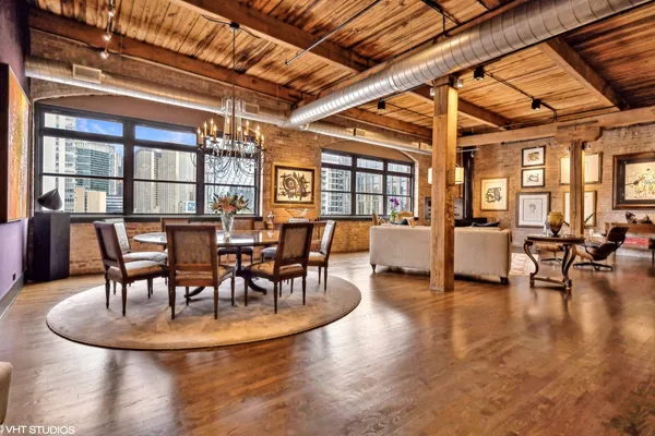 a view of a dining room with furniture a chandelier and wooden floor