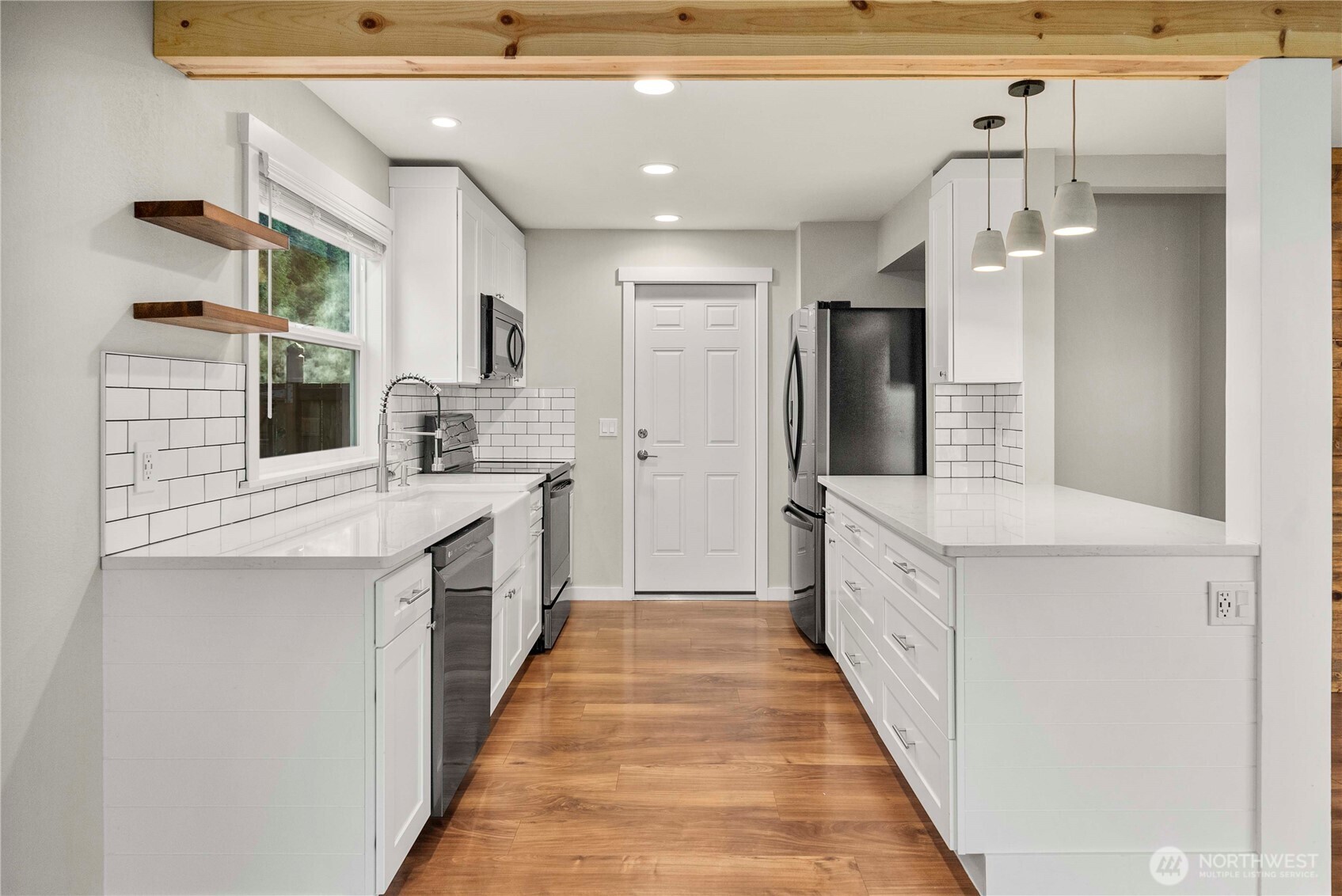21816 Southeast 269th Street Maple Valley, WA 98038 - Photo 10 of 35 a large white kitchen with granite countertop a sink and dishwasher a stove top oven with wooden floor