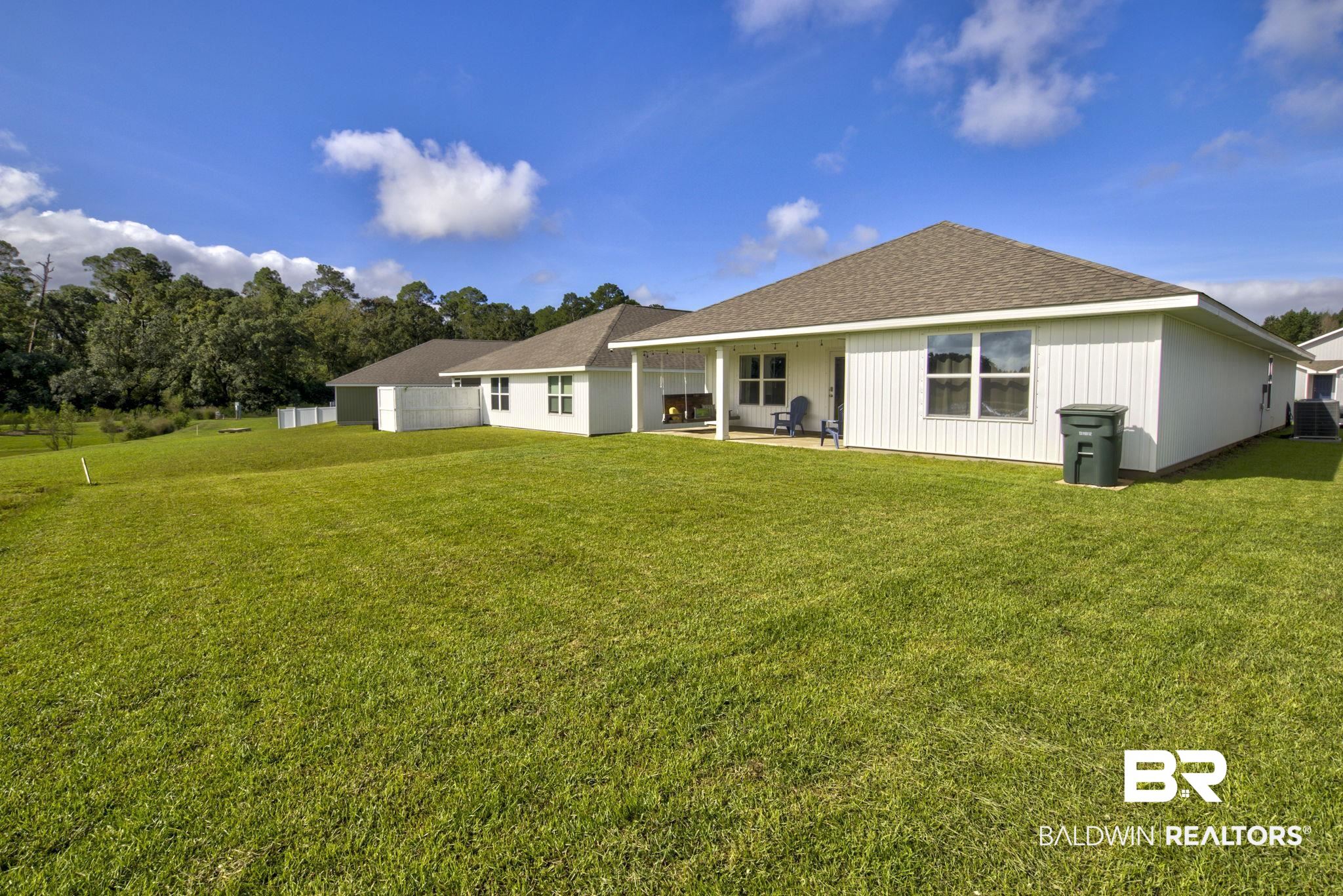23810 Unbridled Loop Daphne, AL 36526 - Photo 31 of 50 Rear view of house featuring a lawn and a patio