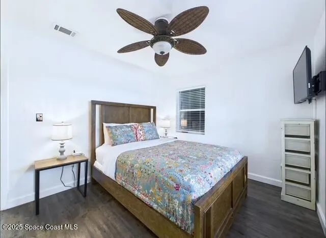 a bedroom with a bed and a flat tv screen on dresser