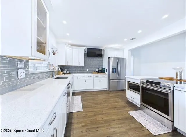 a kitchen with stainless steel appliances granite countertop a stove a sink and a refrigerator