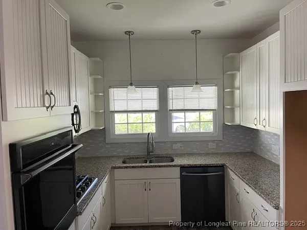 a kitchen with stainless steel appliances granite countertop a sink a stove and a refrigerator