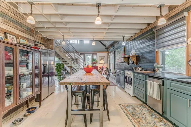 a view of a kitchen with stainless steel appliances granite countertop a sink and wooden cabinets