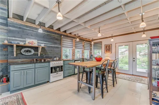 a dining room with stainless steel appliances granite countertop a sink and cabinets