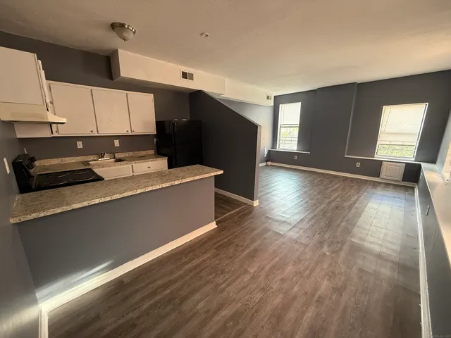 a kitchen with a wooden floor window and cabinets