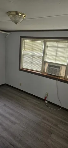 a view of a room with wooden floor and a window
