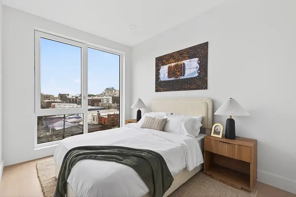 a bedroom with a bed a mirror and lamp