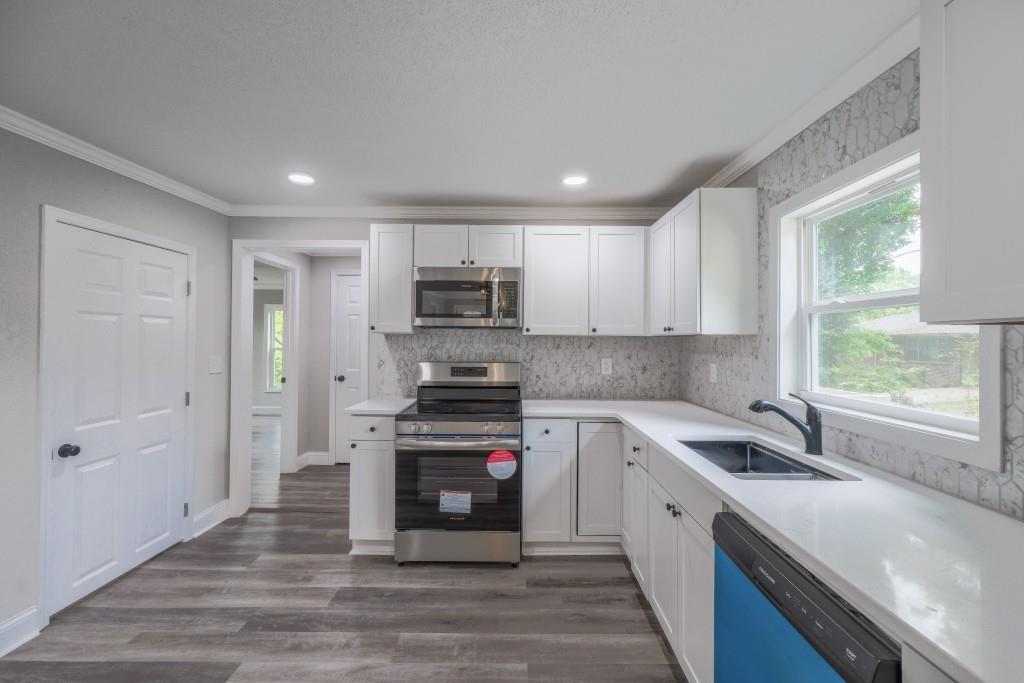 11 Cloverhurst Drive Toccoa, GA 30577 - Photo 8 of 26 a kitchen with stainless steel appliances granite countertop a sink a stove a refrigerator cabinets and a window
