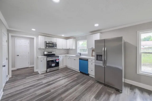 a kitchen with stainless steel appliances a refrigerator sink and cabinets