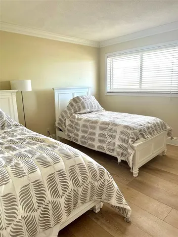 a bedroom with a bed lamp and a window