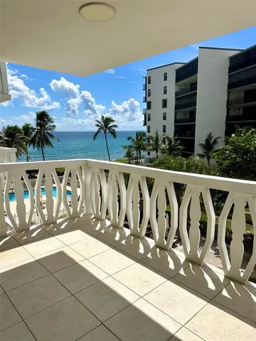 a view of a multi story residential apartment building with a yard