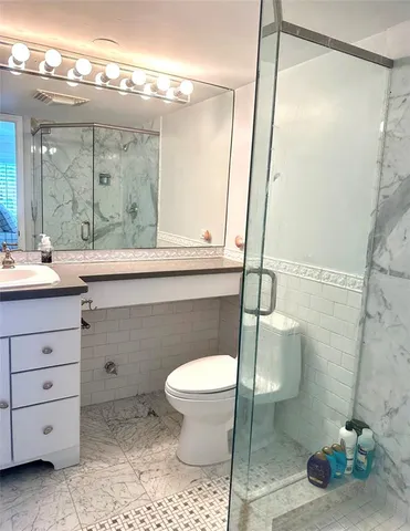 a bathroom with a sink a toilet and shower