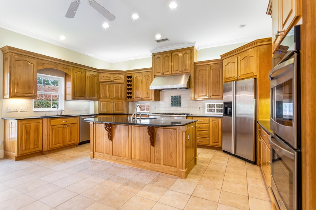 8010 Scudder Way Ball Ground, GA 30107 - Photo 14 of 57 a kitchen with stainless steel appliances granite countertop a sink a stove a refrigerator cabinets and a dining table
