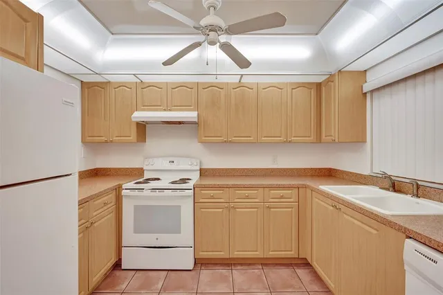 a kitchen with white cabinets and white appliances