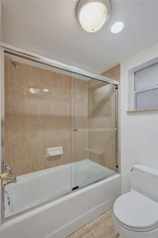 a bathroom with a shower a toilet and a tub