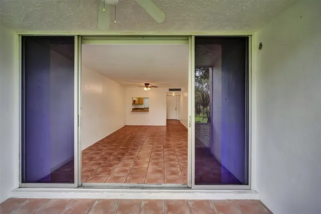 a view of a hallway with wooden floor and a living room