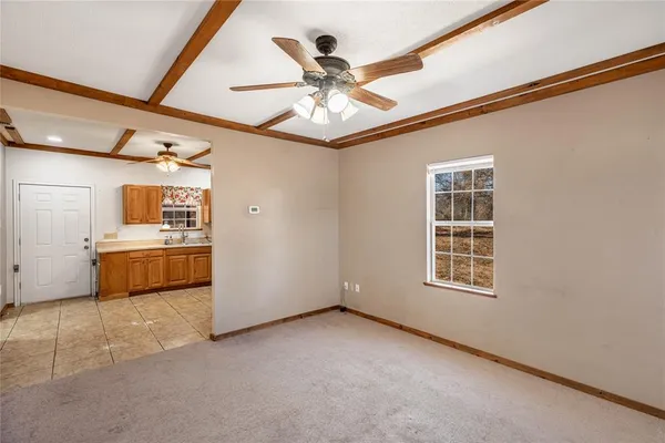 an empty room with windows and ceiling fan