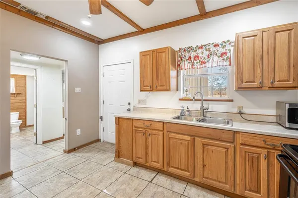 a bathroom with a granite countertop sink mirror and cabinets