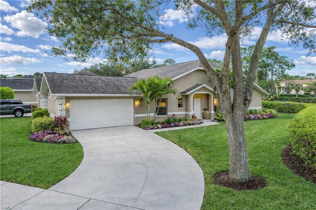 2037 West Crown Pointe Boulevard Naples, FL 34112 - Photo 1 of 24 a front view of a house with a yard and garage