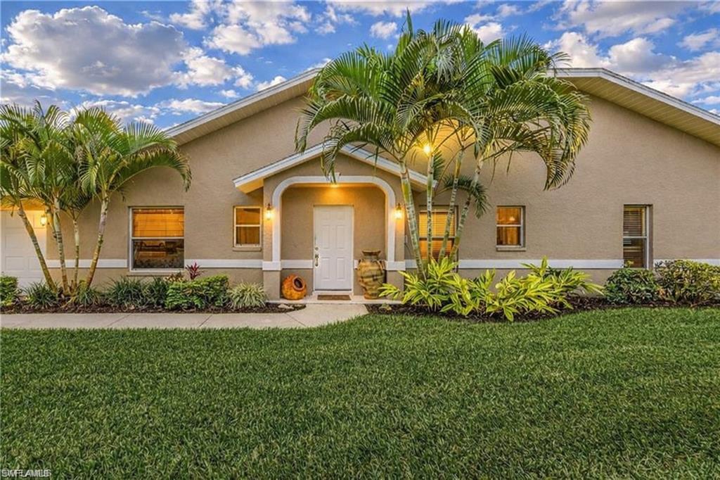 2037 West Crown Pointe Boulevard Naples, FL 34112 - Photo 2 of 24 a front view of a house with a garden and plants