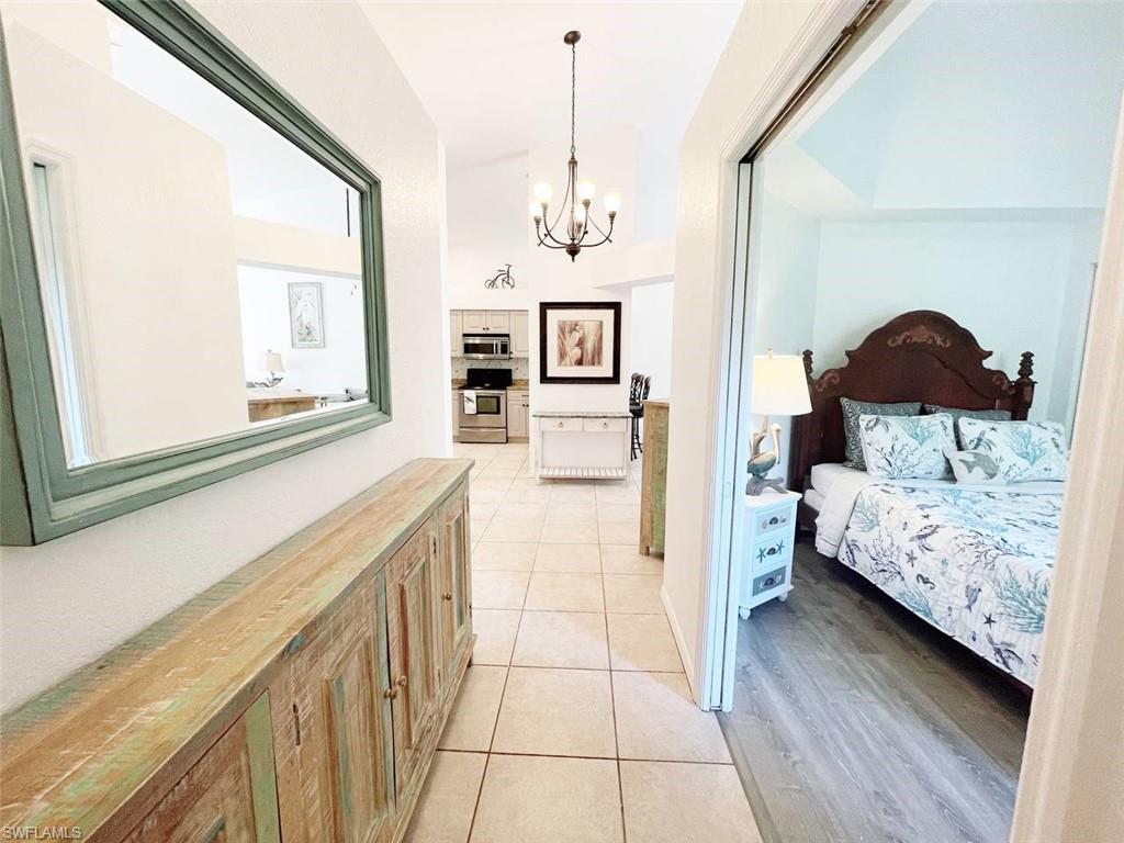 2037 West Crown Pointe Boulevard Naples, FL 34112 - Photo 6 of 24 a bedroom with a bed a mirror and a window