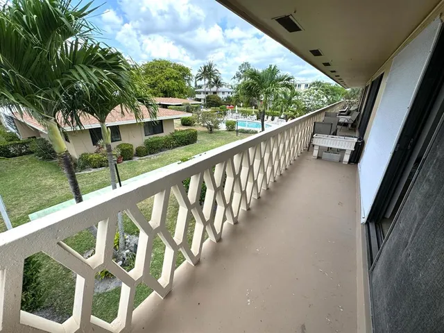 a view of a balcony with wooden floor and fence