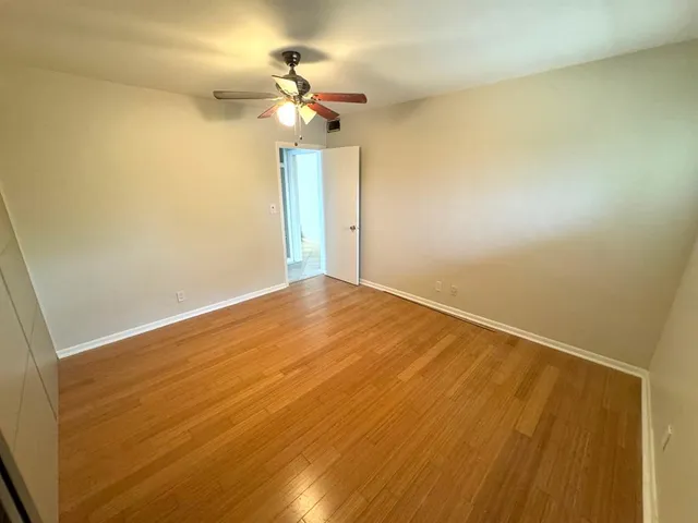 a view of a hallway with wooden floor and staircase