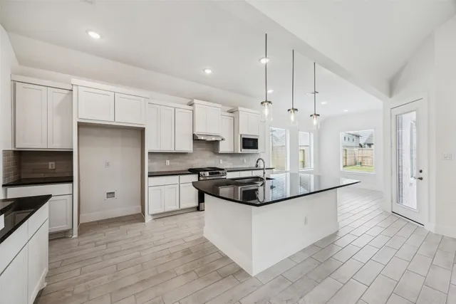 a kitchen with stainless steel appliances granite countertop a stove and a refrigerator